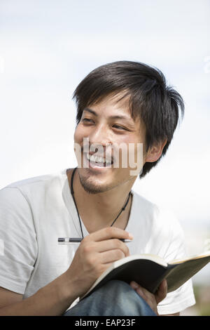 Junger Mann mit einem Notebook im Park. Stockfoto