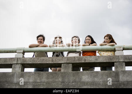 Freunden im Park auf einer Brüstung gelehnt. Ansicht von unten. Stockfoto