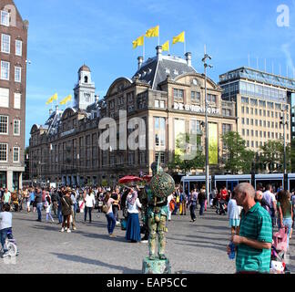 Monumentale Kaufhaus Bijenkorf in Amsterdam an der Ecke Dam und Damrak, Touristen auf der Suche auf eine lebende statue Stockfoto