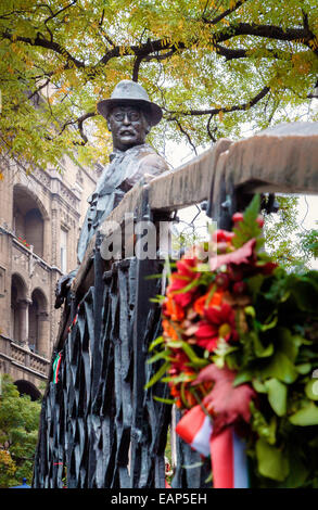 Budapest Ungarn, steht eine Statue von Imar Nagy auf einer Brücke blickte auf Blüten, die an der Gedenkstätte geblieben sind. Stockfoto