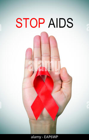 der Text stop AIDS und ein rotes Band in der Hand eines Mannes Stockfoto