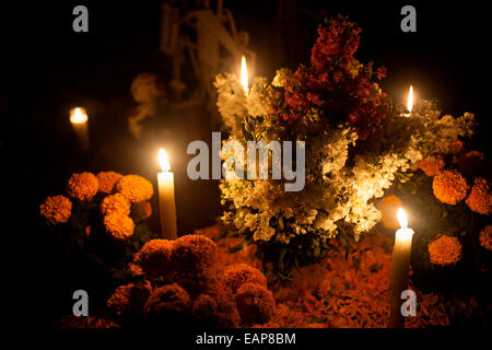 Gelbe Ringelblumen, bekannt als Cempasuchil und Kerzen schmücken ein Grab auf dem Friedhof in San Gregorio Atlapulco, Mexiko Stockfoto