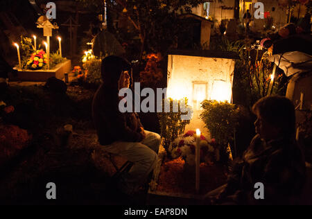 Leute sitzen von einem Grab auf dem Friedhof in San Gregorio Atlapulco, Xochimilco, im Rahmen des Tag der Toten feiern in Mexiko Stockfoto