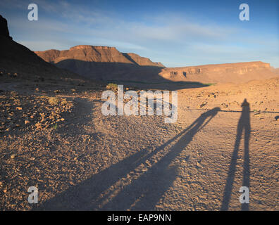 Schatten von Menschen im aufgehenden Sonne kurz nach Sonnenaufgang in der Jebel Sahro Region des Gebirges in Marokko Stockfoto
