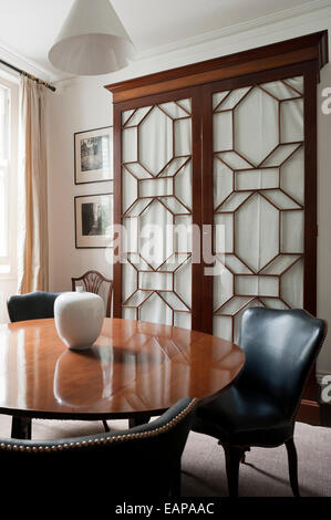 Tisch aus Holz und Leder Stühle im Speisesaal mit französischen Mahagoni Schrank Stockfoto