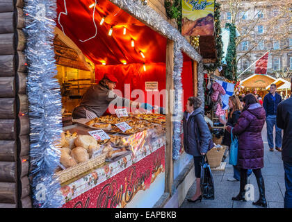 Weihnachten Markt Standinhaber Austausch von Veränderung mit Dame an einem Imbissstand in den Boden der City Hall, Belfast. Stockfoto