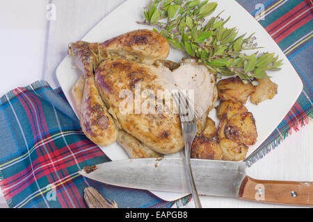 Gebratenes Huhn mit Kartoffeln garniert auf grüne Platte und Tischdecke Schottisch Stockfoto