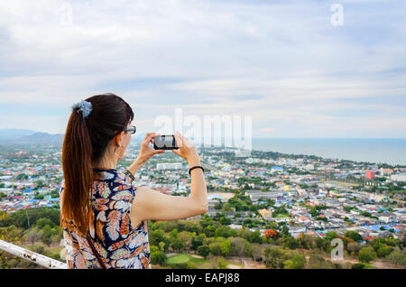 Frau mit Telefon Fotografieren von Hua Hin Stadt von oben. Thailand Stockfoto