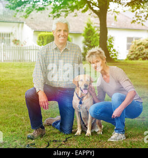 Gerne älteres paar sitzen im Garten mit Labrador Retriever Hund Stockfoto