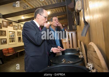 US-Arbeitsminister Thomas Perez Proben Gerste mit Jim Koch, der Gründer der Brauerei Samuel Adams bei einem Rundgang durch den Bier-Maker 17. November 2014 in Boston, MA. Stockfoto