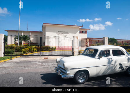 Ein altes Auto übergibt die Vorderseite der Landeszentrale der kubanische Zivilschutz Havana Vorort von Casablanca Stockfoto