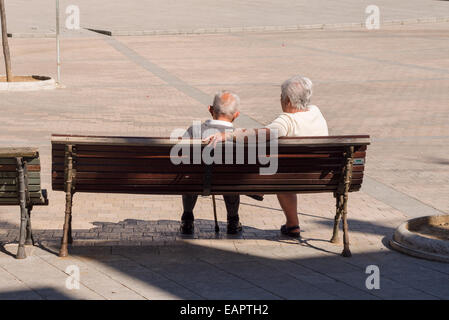 Nehmen eine Rest-Pause auf einer Bank. Ein älteres Ehepaar mit weißen Haaren machen Sie eine Pause auf einer Bank in der zentrale Platz von Besalú. Stockfoto