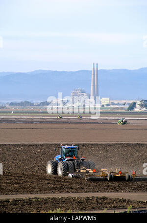 Traktoren Plugh Felder im Monterey County in der Nähe von etwa und das Kraftwerk Moss Landing Stockfoto