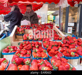 Frische Erdbeeren, wählen die beste Box mit einem Gähnen. Eine Frau wählt eine Schachtel mit Straberries für einen Kunden Stockfoto
