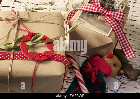 Weihnachtsgeschenke, Retro-Dekoration, Stars und roten Bändern, eingehüllt in Kraftpapier Stockfoto