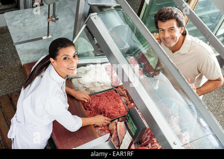 Metzger Hackfleisch an männlichen Kunden zu verkaufen Stockfoto