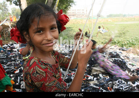 Kinder aus Bangladesh Swing aus einem Baum in Dhaka, Bangladesch ist eines der ärmsten Länder der Welt mit 40 Prozent der 144 Millionen Menschen, die von weniger als 1 Dollar am Tag. Stockfoto