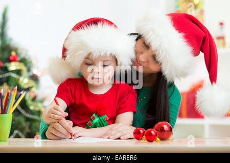 Kind Mädchen und Mutter Weihnachten Brief an den Weihnachtsmann Stockfoto