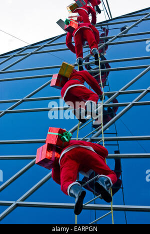 Santa Claus Mannequins Klettern außen einer Shopping Mall. Stockfoto