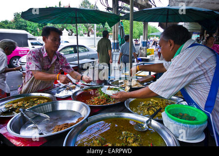 Ein Stall Besitzer dient ein Kunde eine Mittagessen mit Reis und würzigen Bohnen. Stockfoto