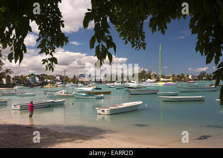 Mauritius, Grand Baie, öffentlicher Strand, Hindu Mann, der betet in Untiefen unter Freizeitboote Stockfoto