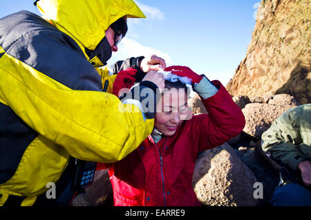 Ein Crew-Mitglied von einem antarktischen Schiff hilft eine Braut mit ihrem Schleier. Stockfoto