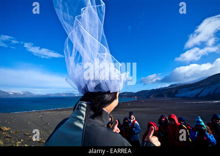 Eine frisch vermählte Braut gibt die Daumen nach ihrer Hochzeit in der Antarktis. Stockfoto