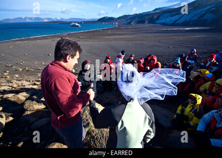 Eine Braut und Bräutigam während ihrer Trauung in der windigen Antarktis. Stockfoto
