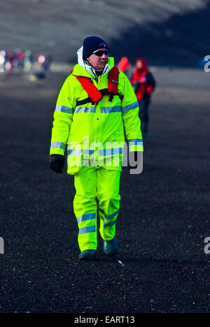 Ein Tourist in fluoreszierenden alpine Kleidung Wandern auf einem vulkanischen Strand. Stockfoto