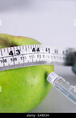 Still Life Konzept Bild eines Apfels Bramley mit Maßband und Insulin Spritze Stockfoto