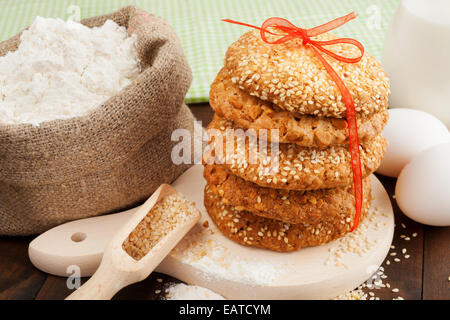 Cookies mit Sesam, Mehl und Eiern auf Küchentisch Stockfoto