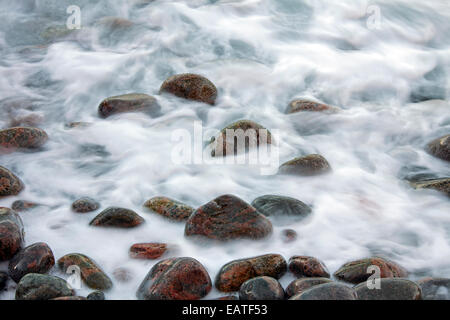 Nahaufnahme von bunten Pflaster bedeckt von Welle am Strand bei Flut Stockfoto