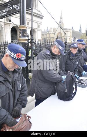 Reihe von englischen London Polizisten tragen Uniform und Mohn Gepäck für Sicherheit-Eintrag von Stadt Westminster Station, England Stockfoto