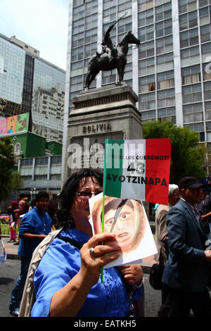 La Paz, Bolivien. 20. November 2014.  Demonstranten passieren eine Statue von Simón Bolivar während eines Marsches um Gerechtigkeit zu fordern für die 43 vermissten Studenten in Mexiko und Protest gegen die mexikanische Regierung Handhabung des Falles und Korruption. Heute wurde ein globaler Aktionstag für Ayotzinapa ausgewiesen; ein landesweiten Streik ist in Mexiko geplant und viele Proteste stattfinden weltweit um Unterstützung zu zeigen. Die Schüler verschwand nach Zusammenstößen mit der Polizei in der Nacht vom 26. September in die Stadt Iguala. Bildnachweis: James Brunker/Alamy Live-Nachrichten Stockfoto