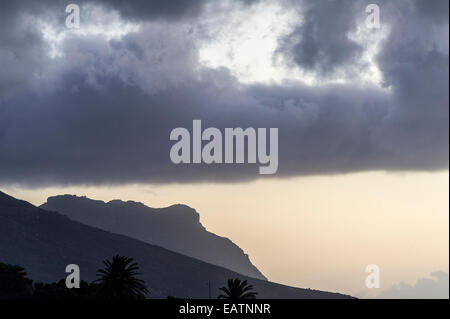 Ein Sturmtief drückt eine Wolkenbank auf einem Berggipfel. Stockfoto