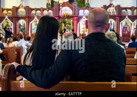 Gäste kommen im Gebet und feiern bei einer griechisch-orthodoxen Hochzeit. Stockfoto