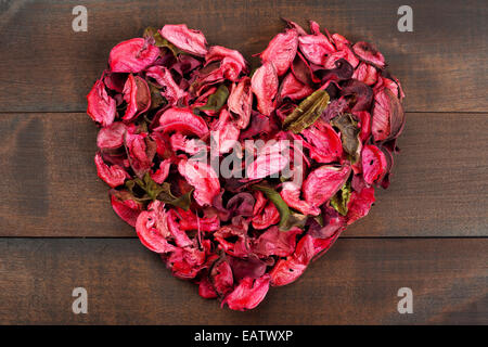 Blütenblätter bilden eine Herzform Holz Hintergrund Stockfoto