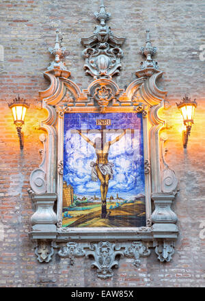 Sevilla, Spanien - 28. Oktober 2014: Die Keramik gefliest Kreuzigung an der Fassade der Kirche Iglesia De La Anunciación in der Abenddämmerung. Stockfoto