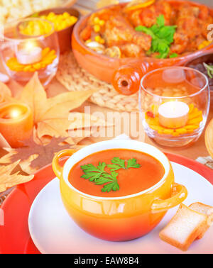 Creme von Kürbissuppe am festlich gedeckten Tisch in der Nähe von gebackenen Türkei und andere leckere Gerichte, leckere vegetarische Suppe, Erntedankfest Stockfoto