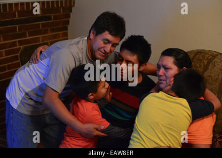 Baltimore, Maryland, USA. 20. November 2014. Pedro Ortega, 45, und seine Frau Maria, 48, Einwanderer aus Ecuador, reagieren benutzen, was Glück, nachdem sie Präsident Obama Adresse auf Zuwanderungsgesetz in ihrem Haus in Baltimore, Maryland Donnerstag Nacht beobachtet. Pedro, der in den USA illegal 1999 kam, funktioniert Wärmeisolierung Häuser. Maria, die ihrem Ehemann im Jahr 2000 wechselte, arbeitet als Haushälterin für ein Pflegeheim. Das Paar hat sechs Kinder: Eddie, 5, amerikanischer Staatsbürger; Lourdes, die für Obamas Nachträglichkeit für Kindheit Ankünfte Programm qualifiziert; und Pedro Jr., der in den USA angekommen Stockfoto