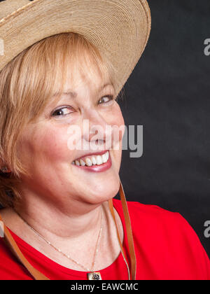 Glücklich Reife Frau in rotem Hemd und Cowgirl Hut Stockfoto