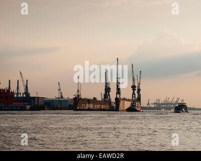 Die Sonne versinkt nach einer leeren Trockendock der Deutschen Werft, die "Blohm + Voss" schwebt auf der Elbe im Hamburger Hafen. Stockfoto