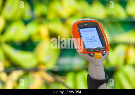 Ein handheld Subito Selfscanning-Gerät fest mit einem Warenkorb in einem Migros-Supermarkt in Zürich, Schweiz. Stockfoto