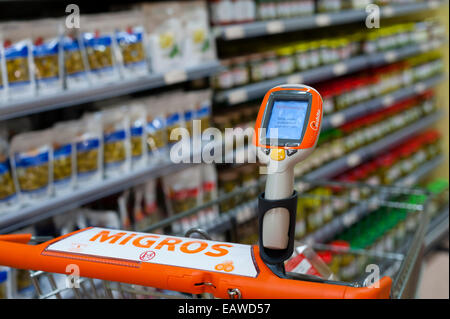 Ein handheld Subito Selfscanning-Gerät fest mit einem Warenkorb in einem Migros-Supermarkt in Zürich, Schweiz. Stockfoto