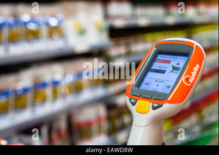 Ein handheld Subito Selfscanning-Gerät fest mit einem Warenkorb in einem Migros-Supermarkt in Zürich, Schweiz. Stockfoto