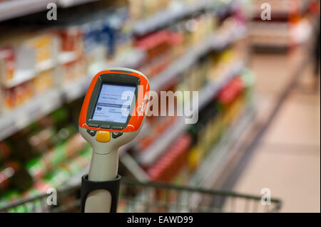 Ein handheld Subito Selfscanning-Gerät fest mit einem Warenkorb in einem Migros-Supermarkt in Zürich, Schweiz. Stockfoto