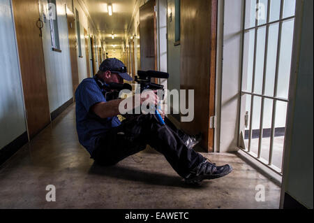 Ein Kameramann filmt die Gefängniszelle von Nelson Mandela bewohnt. Stockfoto