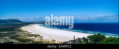 Einen unberührten weißen Sandstrand entlang einer weiten Bucht unter ein Sommerhimmel. Stockfoto