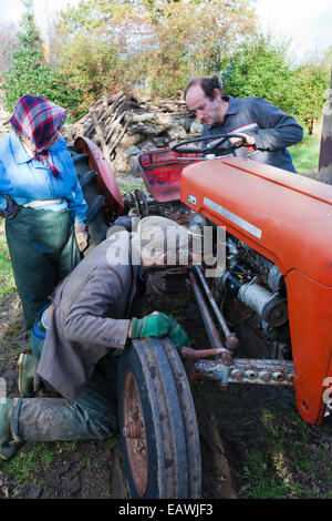 Cumbrian Bauer Tom Brown, seine Frau Jean & Sohn Gordon Kontrolle über ein nicht-Start-Traktor auf seiner Farm in Irthington, Cumbria UK Stockfoto