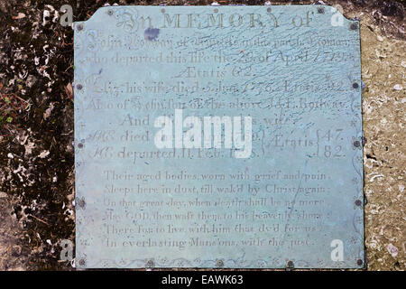 Messingplakette auf einem Grabstein auf dem Friedhof der St. Marys Kirche in der Cotswold-Dorf Edgeworth, Gloucestershire UK Stockfoto